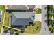 Aerial view of a well-maintained house with a dark roof, green lawn, and landscaped surroundings at 1853 Pasqua Pl, The Villages, FL 32163