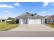 Charming home featuring a three-car garage and well-manicured lawn on a sunny day at 1853 Pasqua Pl, The Villages, FL 32163