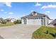 Three-car garage with carriage doors on a well-maintained, light blue home at 1853 Pasqua Pl, The Villages, FL 32163