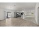 Bright open-concept living area with modern gray kitchen, wood flooring, and sliding glass door to outdoor space at 1853 Pasqua Pl, The Villages, FL 32163