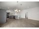 Open-concept living and dining area featuring gray kitchen cabinets and a stylish chandelier at 1853 Pasqua Pl, The Villages, FL 32163