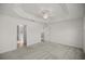 Main bedroom with plush carpeting, tray ceiling, and an ensuite bathroom at 1853 Pasqua Pl, The Villages, FL 32163