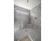 Elegant walk-in shower with gray tiling, built-in seat, and glass enclosure at 1853 Pasqua Pl, The Villages, FL 32163