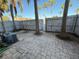 A fenced backyard shows a brick patio with air conditioning units and palm trees at 1928 Conway Rd # 23, Orlando, FL 32812