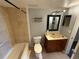 Bathroom featuring a vanity with dark wood cabinets, a black framed mirror, and a tiled shower/tub combination at 1928 Conway Rd # 23, Orlando, FL 32812