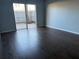 Bedroom with dark hardwood floors, gray walls, and sliding doors that lead to a private brick patio at 1928 Conway Rd # 23, Orlando, FL 32812