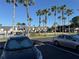 Community exterior shot of apartments with palm trees, parking lot, and neighboring cars at 1928 Conway Rd # 23, Orlando, FL 32812