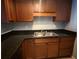 This cozy kitchen offers dark counters, wooden cabinets, and a stainless steel sink at 1928 Conway Rd # 23, Orlando, FL 32812