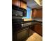 This cozy kitchen features black appliances, dark counters, and bright wooden cabinets at 1928 Conway Rd # 23, Orlando, FL 32812