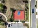 Aerial shot of community basketball court with a red and blue playing surface, surrounding landscaping and parking at 2183 Ridge Pointe Ln, Clermont, FL 34715