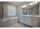 A luxurious bathroom featuring a soaking tub, separate shower, and a dual sink vanity at 2183 Ridge Pointe Ln, Clermont, FL 34715