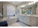 Luxurious main bathroom features a soaking tub, double vanity, and a separate glass-enclosed shower at 2183 Ridge Pointe Ln, Clermont, FL 34715