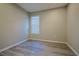 This is a bedroom with gray wood floors, neutral walls, and a light-filled window at 2183 Ridge Pointe Ln, Clermont, FL 34715