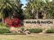 A stone sign for Highland Ranch, with vibrant flowers, lush greenery and mature trees at 2183 Ridge Pointe Ln, Clermont, FL 34715