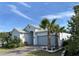 Attractive single-story home with brick driveway, two palm trees, and a cozy bench at 2183 Ridge Pointe Ln, Clermont, FL 34715