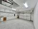 Spacious two car garage with gray epoxy flooring and overhead rack storage at 2183 Ridge Pointe Ln, Clermont, FL 34715