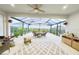 Bright sunroom with ceiling fan, outdoor furniture, and potted plants creating a relaxing indoor-outdoor space at 2183 Ridge Pointe Ln, Clermont, FL 34715