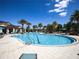 Community pool featuring ample lounge chairs, palm trees, and resort-style amenities at 2183 Ridge Pointe Ln, Clermont, FL 34715