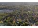 Scenic aerial shot of a residential area bordering a tranquil lake, surrounded by dense trees at 219 N Rossiter St, Mount Dora, FL 32757