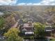 Overhead shot showcasing the property and its tree-filled surroundings near a tranquil lake and clear blue skies at 219 N Rossiter St, Mount Dora, FL 32757
