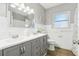 Bright bathroom with double sinks, gray cabinetry, and a tiled wall at 219 N Rossiter St, Mount Dora, FL 32757