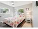 Cozy bedroom with light walls, hardwood floors, two windows and a floral themed bedspread at 219 N Rossiter St, Mount Dora, FL 32757