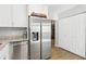 Modern kitchen with stainless steel refrigerator, granite counters, and white cabinets at 219 N Rossiter St, Mount Dora, FL 32757