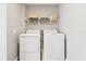 Dedicated laundry room equipped with a washer, dryer, and overhead storage shelf at 219 N Rossiter St, Mount Dora, FL 32757