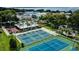 Overhead shot of multiple well-maintained tennis courts and covered seating area in a beautiful community at 219 N Rossiter St, Mount Dora, FL 32757