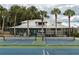 Well-maintained tennis courts near a clubhouse and mature palm trees offer a great recreational amenity at 219 N Rossiter St, Mount Dora, FL 32757