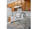 Modern kitchen featuring granite countertops, wooden cabinets, and a stainless steel faucet at 2210 Stonington Ave # 2210, Orlando, FL 32817