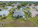 Aerial view of a home with gray roof, lush landscaping, and a quiet neighborhood at 22247 Draw Bridge Dr, Leesburg, FL 34748