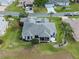 Aerial view of a gray roof home with screened patio, and lush landscaping in a quiet neighborhood at 22247 Draw Bridge Dr, Leesburg, FL 34748