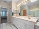 Bathroom featuring a double sink vanity, toilet, and a glass door shower at 22247 Draw Bridge Dr, Leesburg, FL 34748