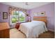 Bedroom with light purple walls, natural light, and soft carpet at 22247 Draw Bridge Dr, Leesburg, FL 34748