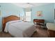 Bedroom featuring soft blue walls, a wicker headboard, and a ceiling fan at 22247 Draw Bridge Dr, Leesburg, FL 34748
