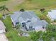 Beautiful single-story home with a well-manicured lawn, lush landscaping, and gray roof at 22247 Draw Bridge Dr, Leesburg, FL 34748