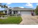 Well-maintained single-story home featuring a two-car garage, lush landscaping, and a manicured front yard at 22247 Draw Bridge Dr, Leesburg, FL 34748