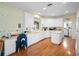 Bright kitchen with white cabinetry, an island, hardwood floors, and an adjacent laundry room at 22247 Draw Bridge Dr, Leesburg, FL 34748