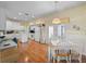 Eat-in kitchen featuring white cabinets, light countertops, wood flooring, and backyard access at 22247 Draw Bridge Dr, Leesburg, FL 34748