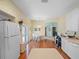 Eat in kitchen with white cabinetry, hardwood floors, and white appliances at 22247 Draw Bridge Dr, Leesburg, FL 34748