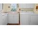 Functional laundry room with white cabinets and a washing machine and dryer at 22247 Draw Bridge Dr, Leesburg, FL 34748