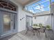 Relaxing screened patio featuring a cozy seating area with a table and chairs and double door access to the home at 22247 Draw Bridge Dr, Leesburg, FL 34748