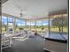 Spacious sunroom with multiple seating areas, ceiling fans, and scenic views at 22247 Draw Bridge Dr, Leesburg, FL 34748