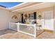 Inviting front porch features hanging flower baskets and cozy seating, perfect for enjoying the outdoors at 2334 Welcome Way, The Villages, FL 32162