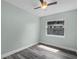 Comfortable bedroom featuring gray wood floors, a ceiling fan, and a large window at 234 S Central Ave, Apopka, FL 32703
