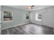 Spacious bedroom with gray wood floors and a ceiling fan, featuring built-in storage at 234 S Central Ave, Apopka, FL 32703