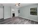 Inviting bedroom with gray wood floors and ensuite bathroom; features ample natural light from a side window at 234 S Central Ave, Apopka, FL 32703