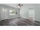 Bright and airy living room with gray wood-look floors, a ceiling fan, and a front door at 234 S Central Ave, Apopka, FL 32703