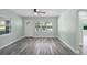 Bright and airy living room with gray wood-look floors, a ceiling fan, and natural light at 234 S Central Ave, Apopka, FL 32703